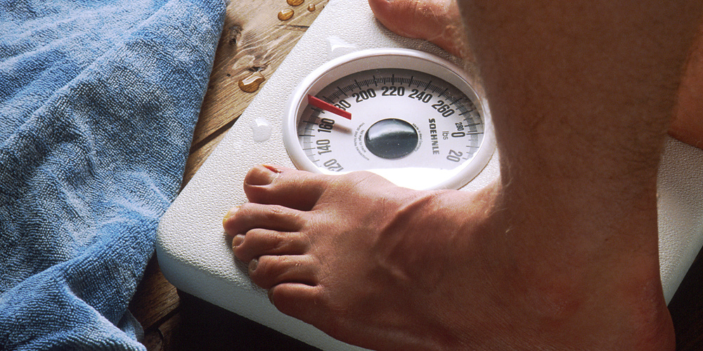 Feet standing on a bathroom scale for a BMI check